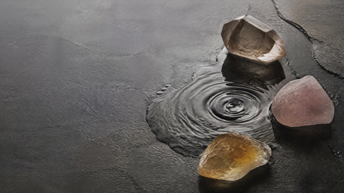 Smoky quartz, rose quartz and citrine around a quiet water ripple
